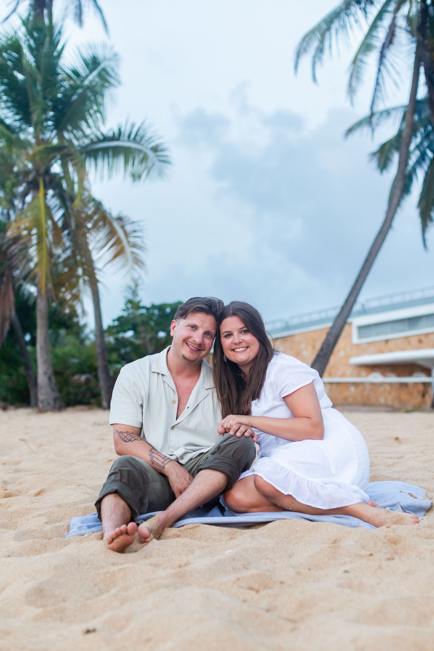 Couples portrait seated on the beach at Balneario del Escambrón in Old San Juan, Puerto Rico.