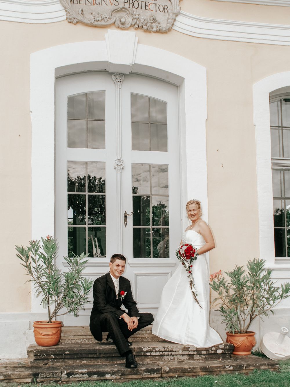 Brautpaar vor dem prunkvollen Portal von Schloss Thurn – Hochzeitsfotografin für authentische Bilder