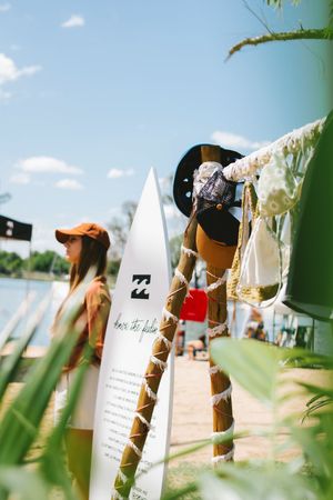 Billabong surfboard display near a lakeside dock on a sunny day.