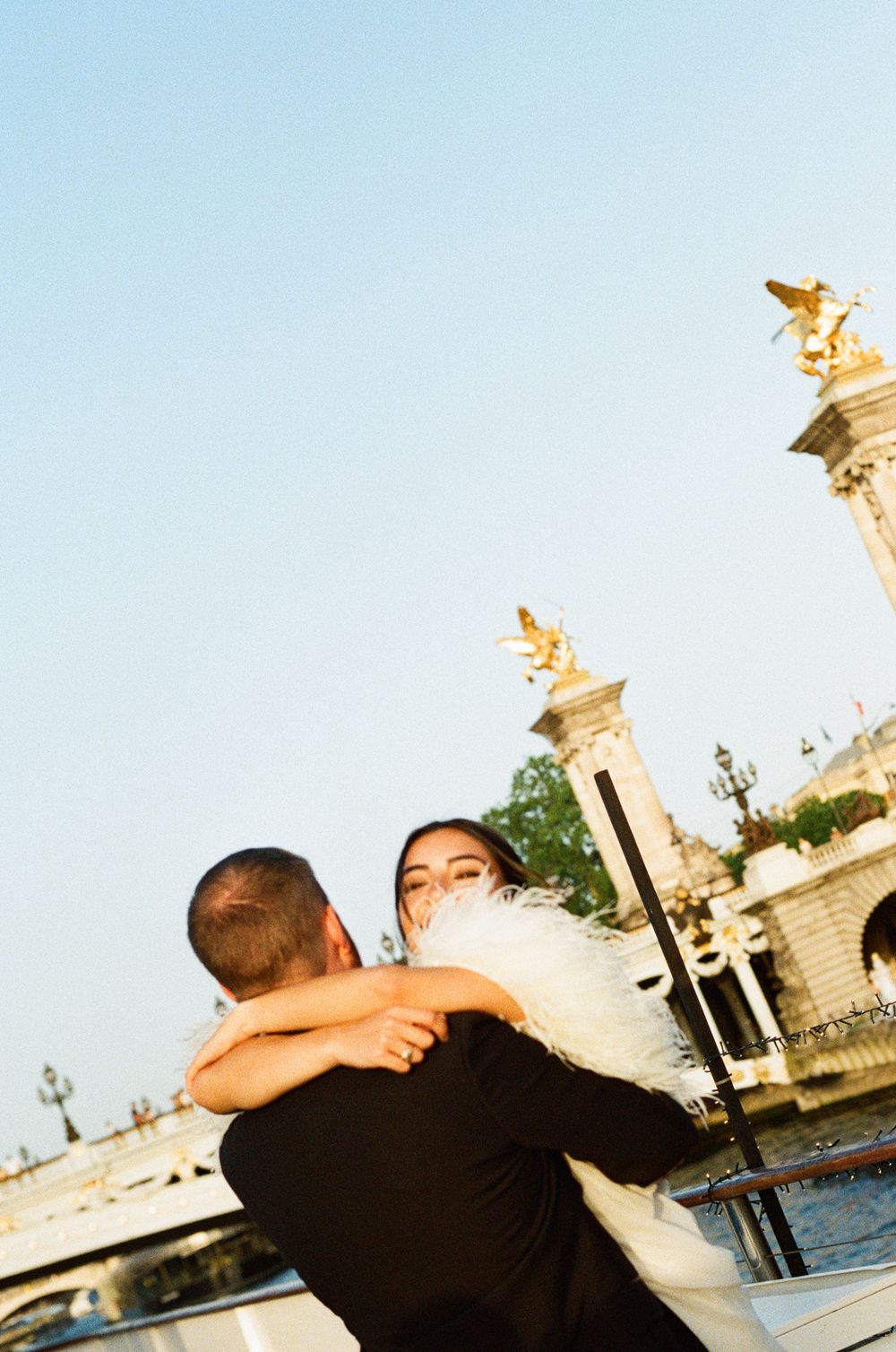 Couple embracing romantically on the Pont Alexandre III bridge in Paris with golden statues in the background. paris wedding photographer
