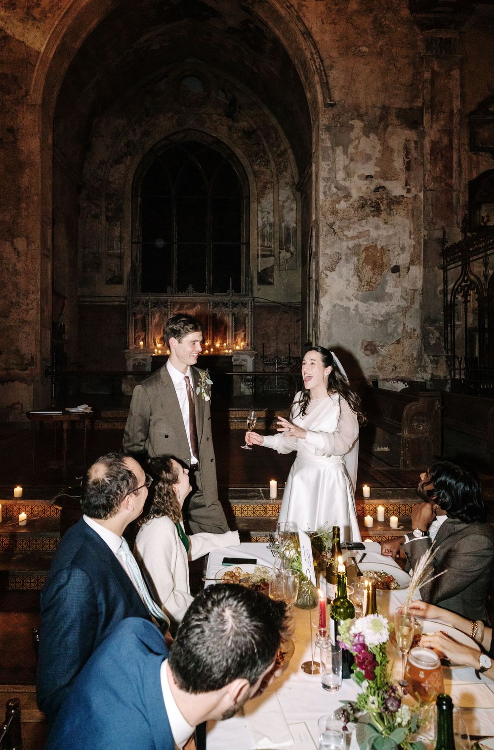 Bride and groom share a toast with guests at a candlelit wedding reception at  The Mount without Bristol