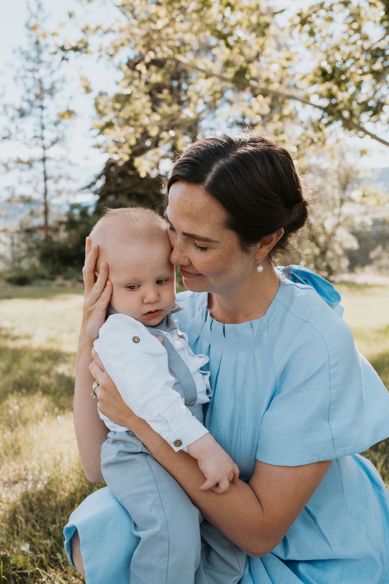 Mom & Baby cuddling in South Okanagan generations photography session featuring multiple family members in a natural garden setting.