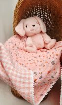 Pink gingham baby blanket with a soft plush bunny toy, perfect for newborns, displayed in a wicker basket.