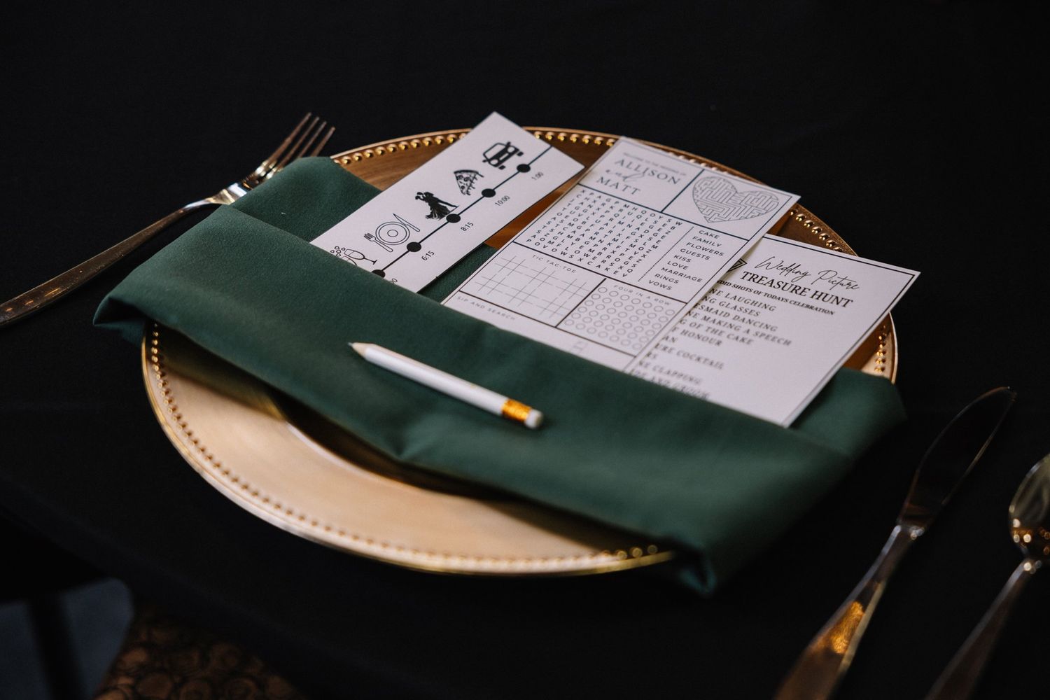 Gold charger, green napkin and personalized Allison and Matt activity card at their Canmore wedding reception