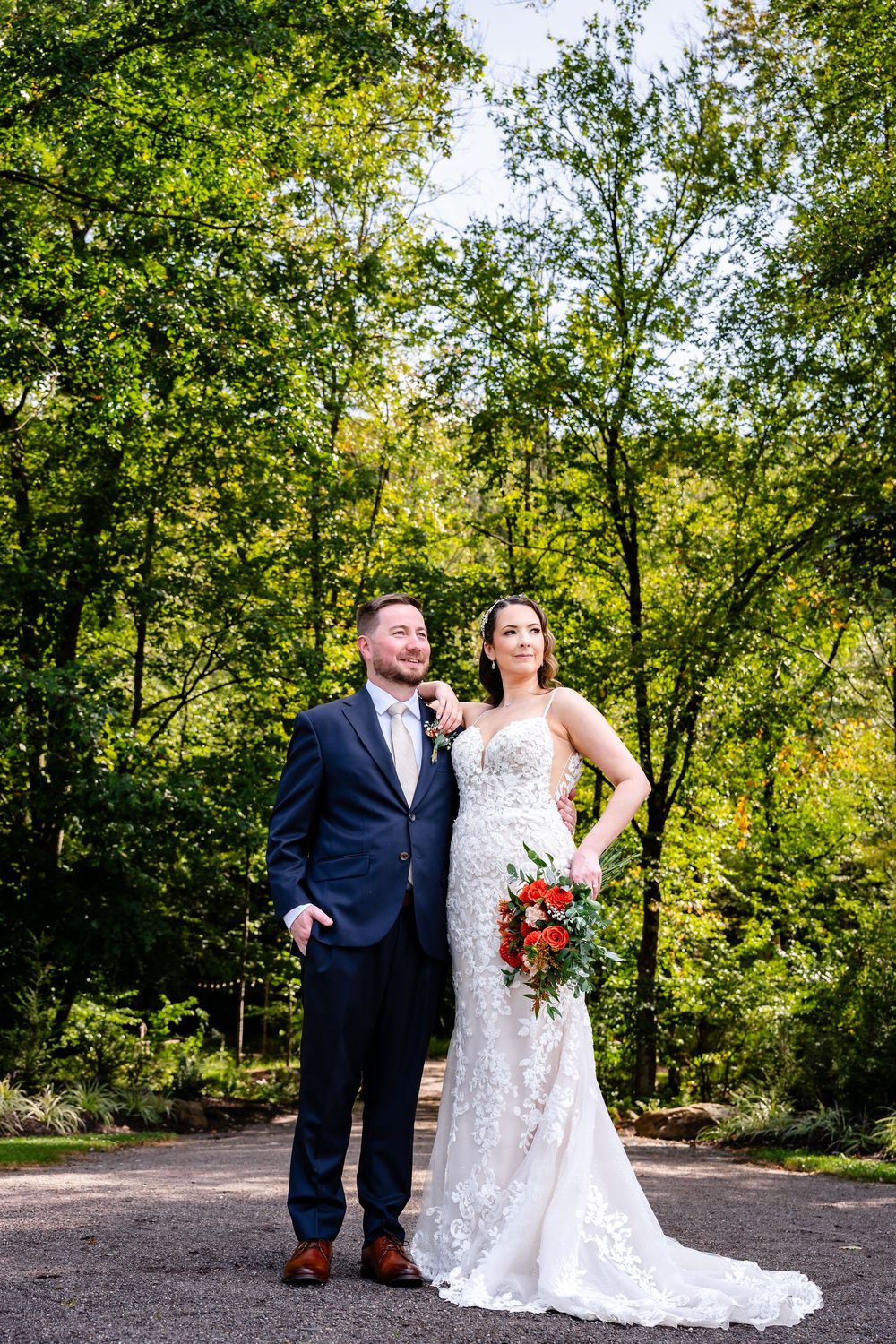 Bride and groom posing together in lush green garden on their wedding day.