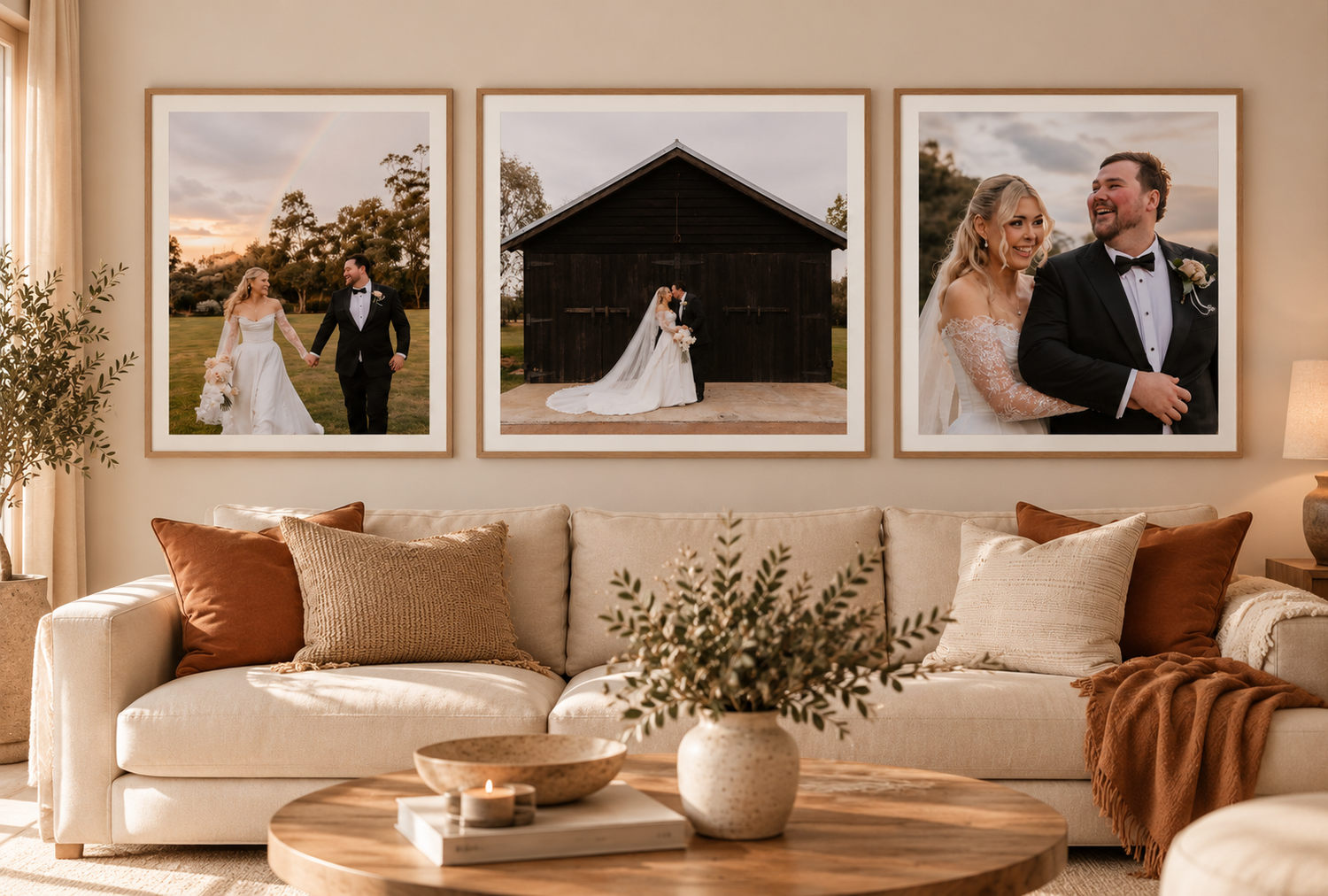 Cozy living room with a cream sofa, rust and neutral pillows, and a wood coffee table beneath three framed wedding photos of a couple.