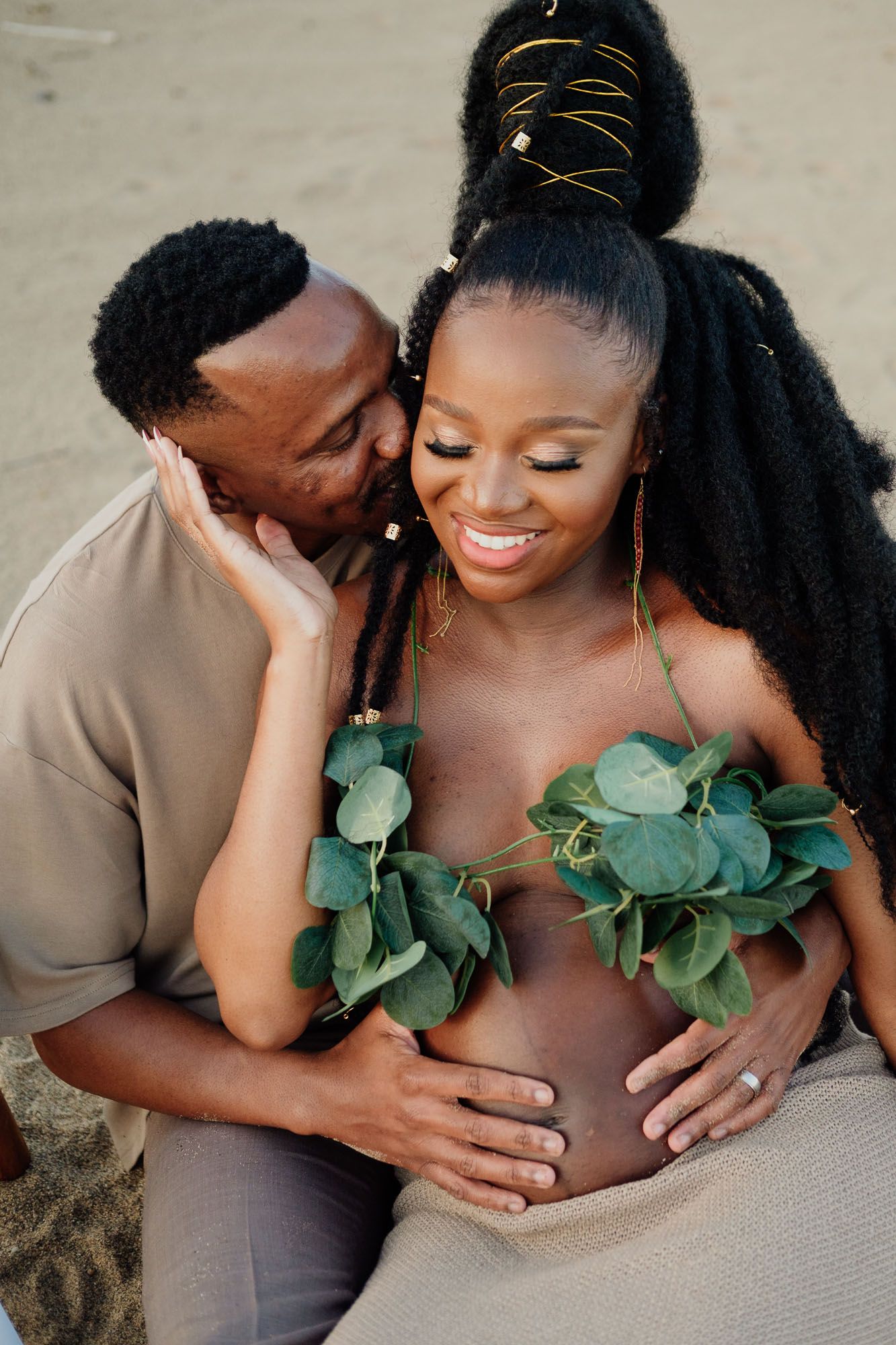 Thembeka and Siya embracing during their maternity photoshoot at Mtunzini Beach