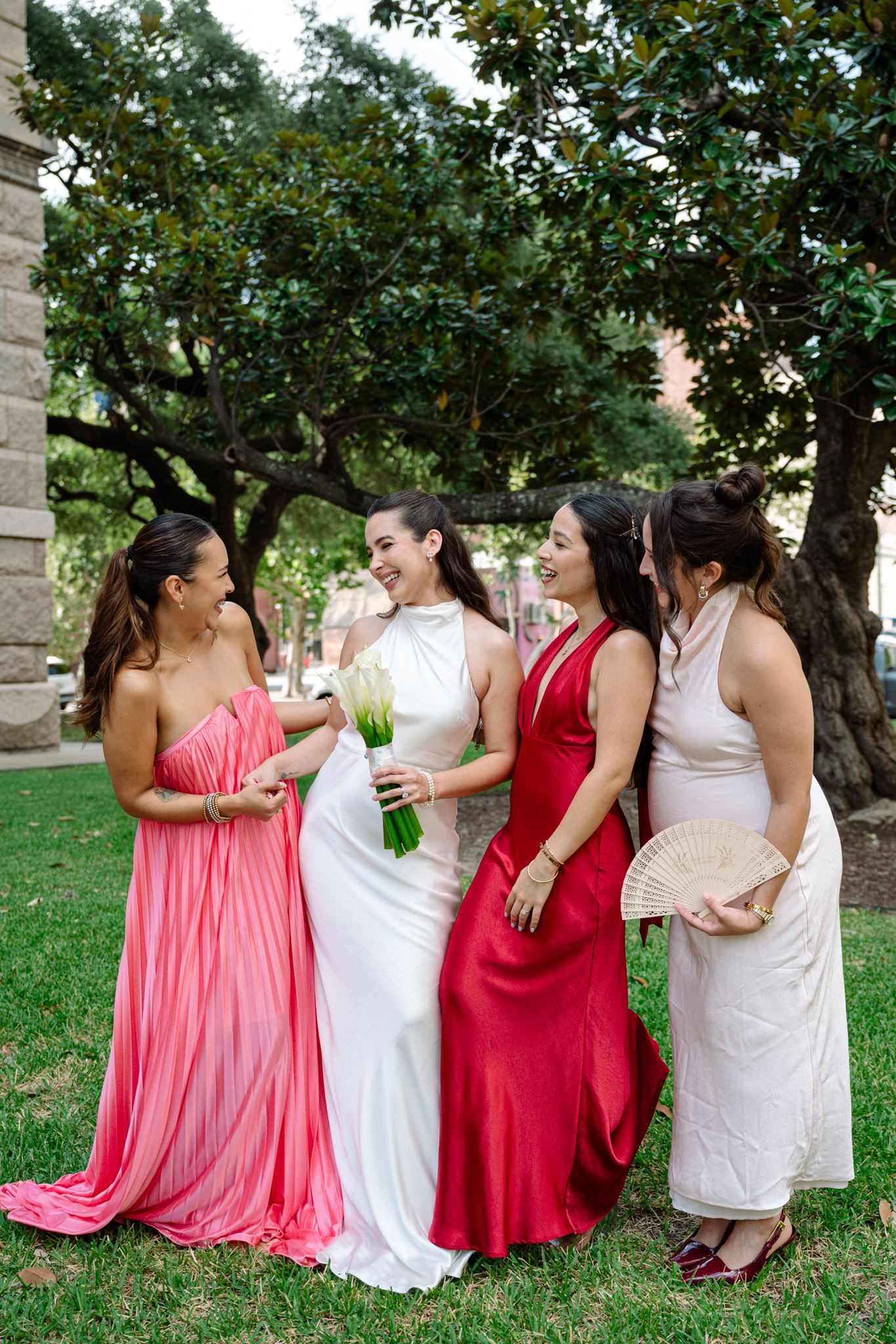 A bride and three women share a laugh under a Southern Magnolia tree in downtown Houston.