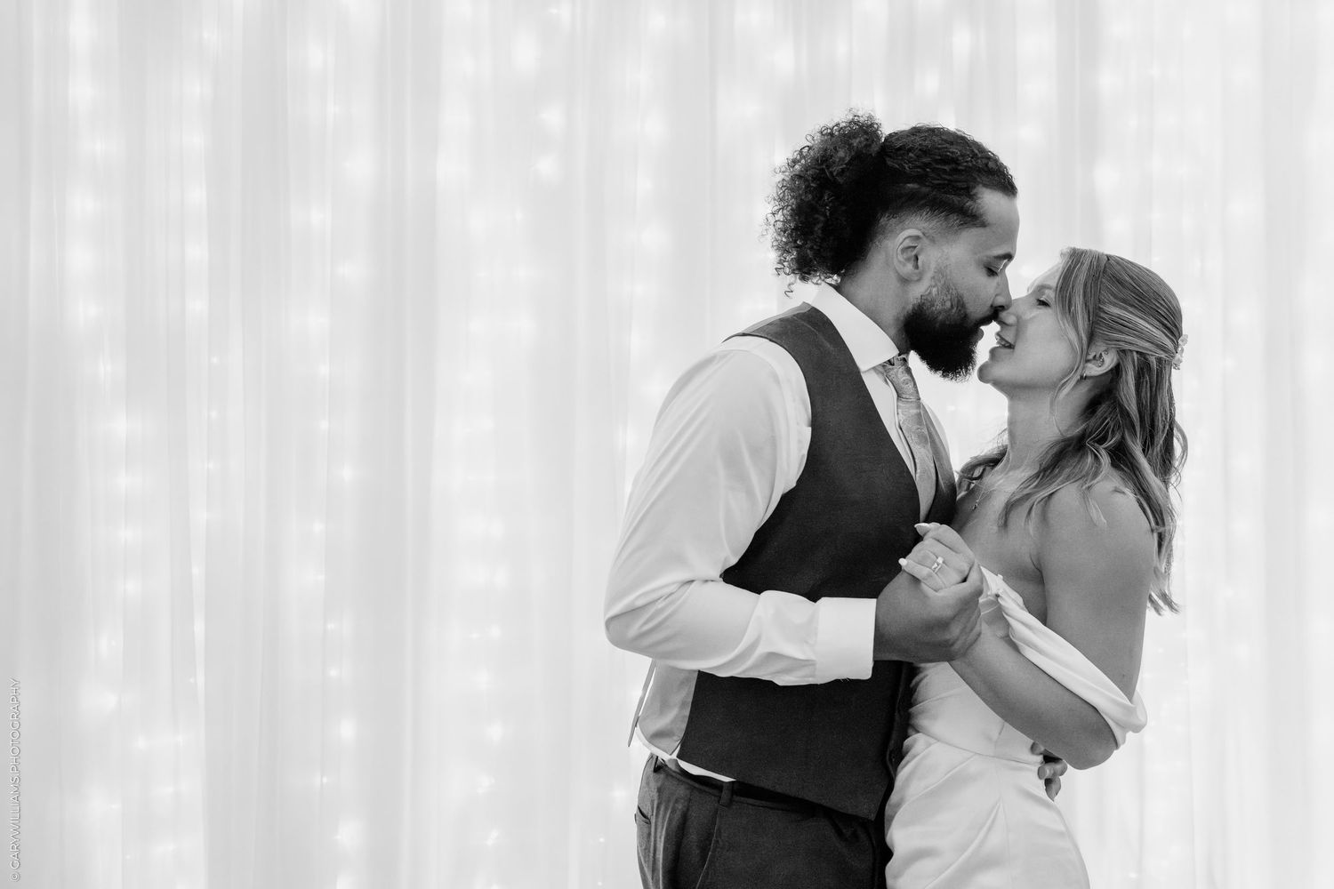 Black and white photo of a couple sharing a romantic first dance at their wedding reception.