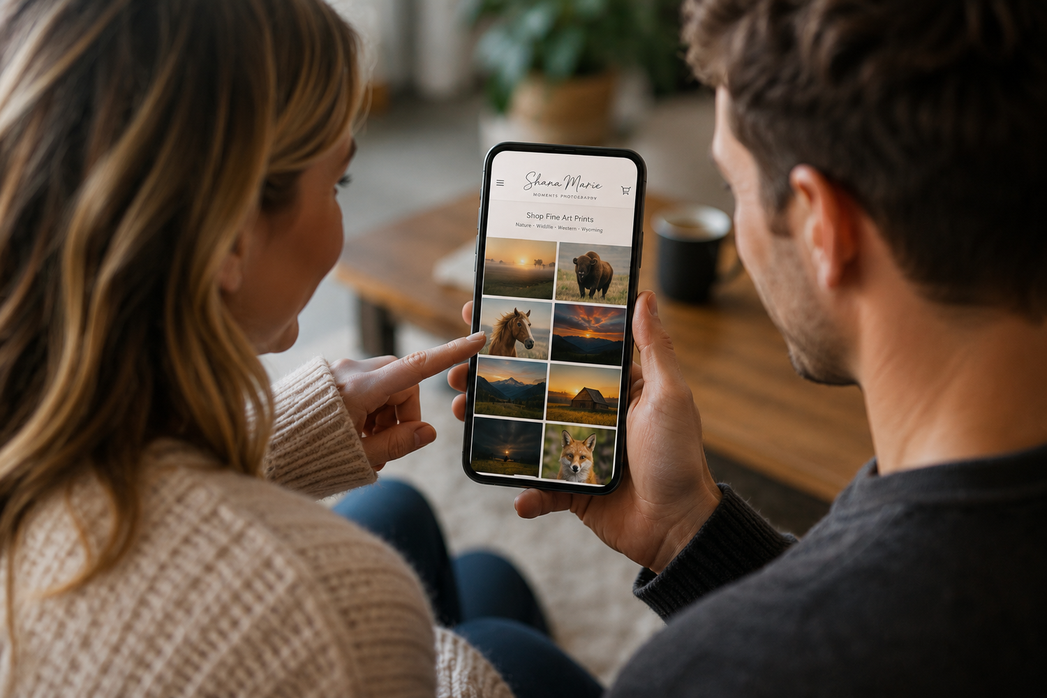 Couple browsing wildlife photography portfolio on smartphone, viewing scenic animal photos together indoors.