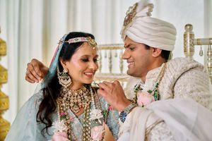 Indian bride and groom sharing intimate moment in traditional wedding attire.