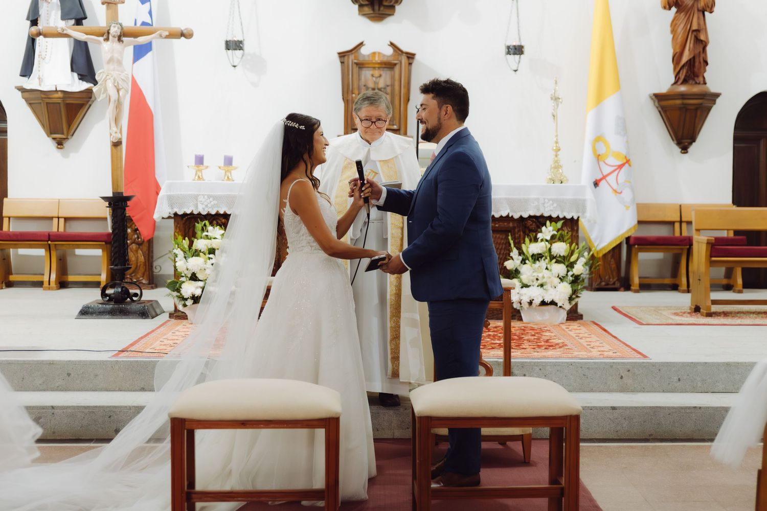 Bride and groom exchange vows at the altar during a Catholic church wedding ceremony.