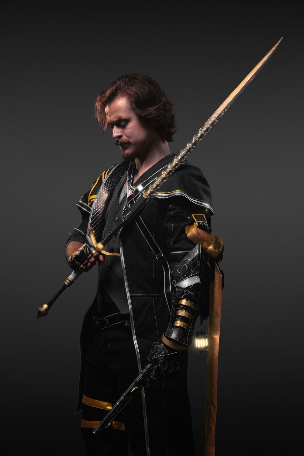 A cosplayer in black and gold armor holds a long ornate spear, posing dramatically against a dark background.