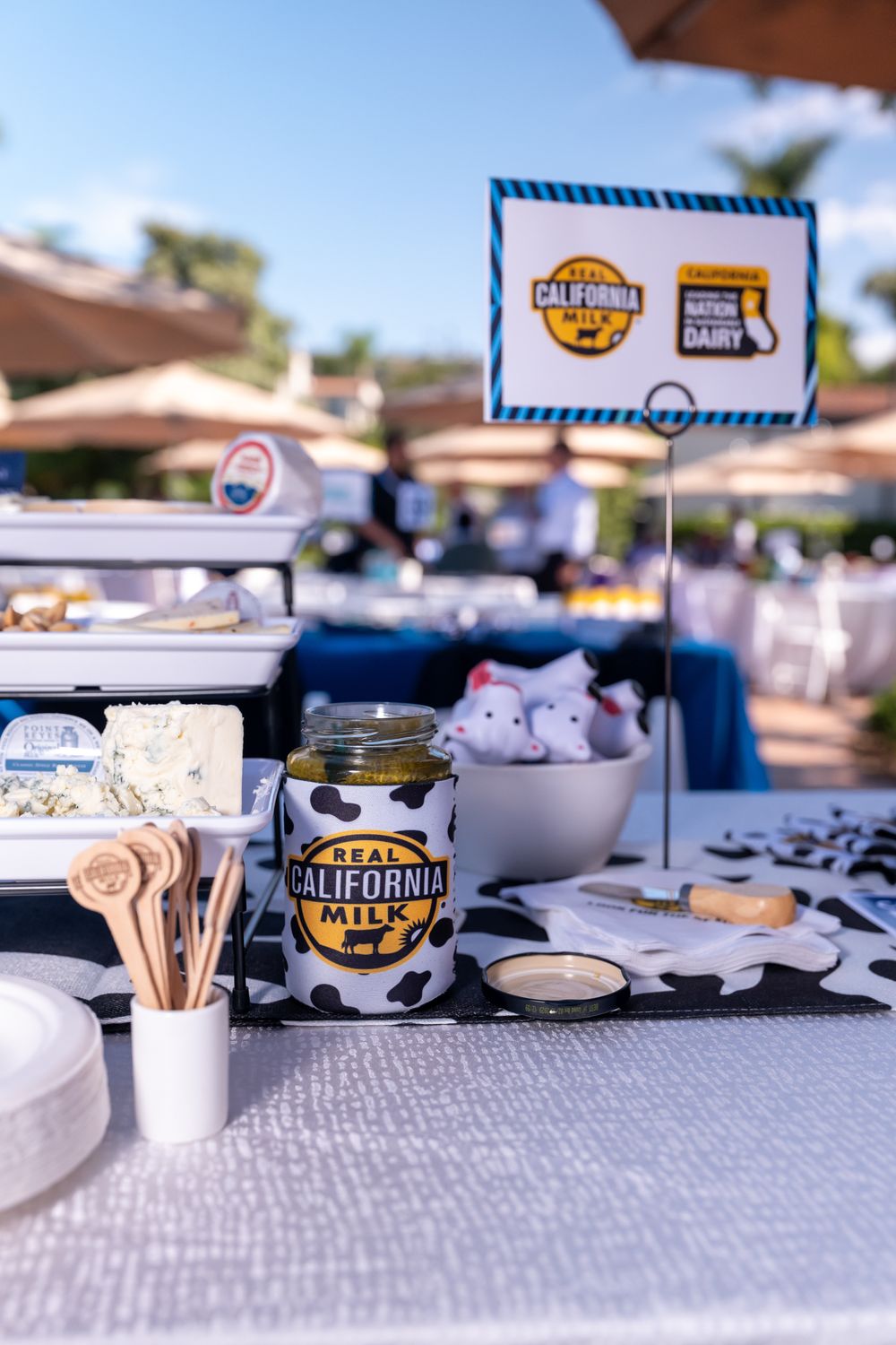 Real California Milk branded jar and cheese display at an outdoor dairy event with promotional signage.