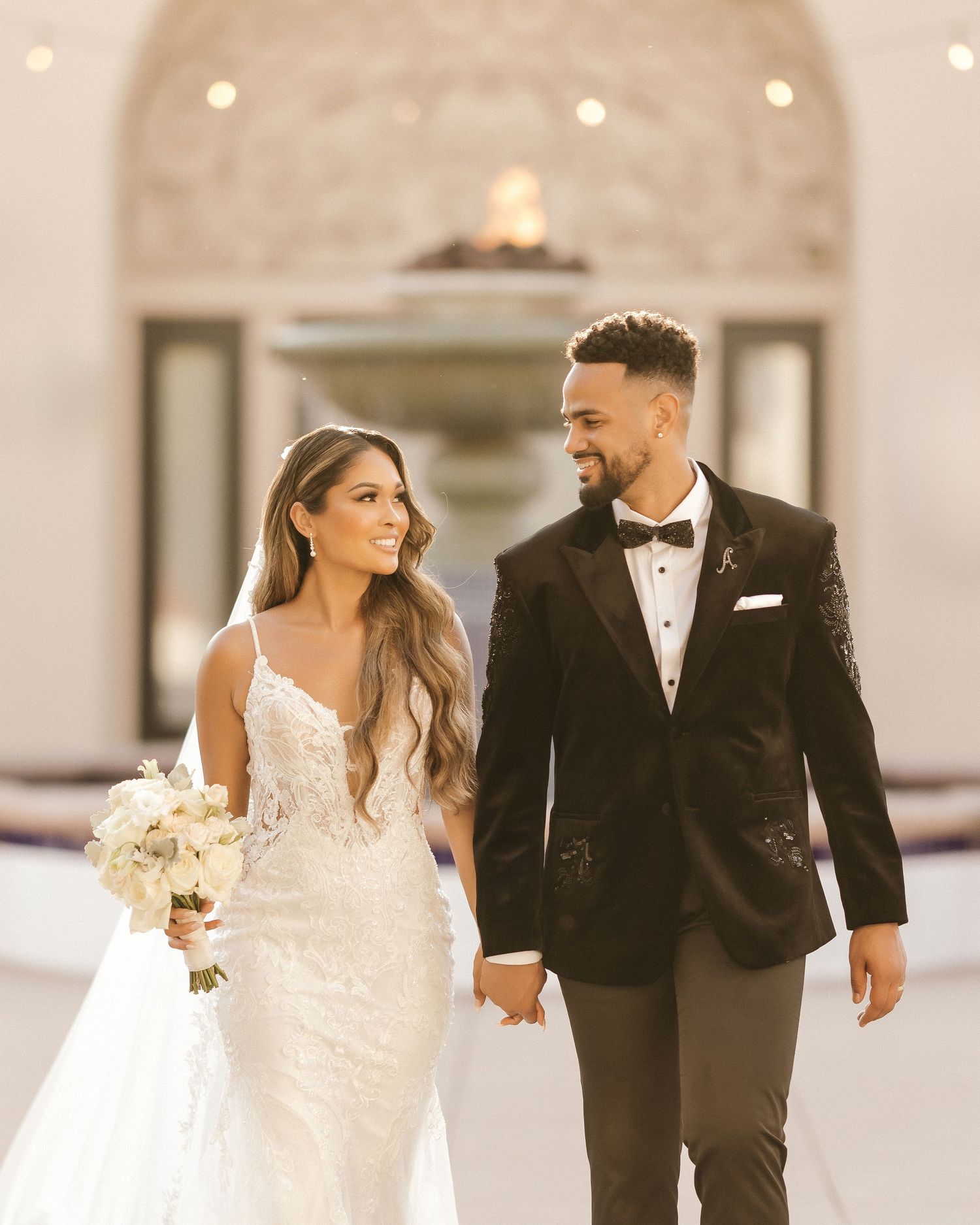 Elegant couple in formal wedding attire pose for sophisticated portrait.