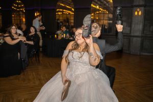 Dancing and celebration during wedding reception in dimly lit venue.