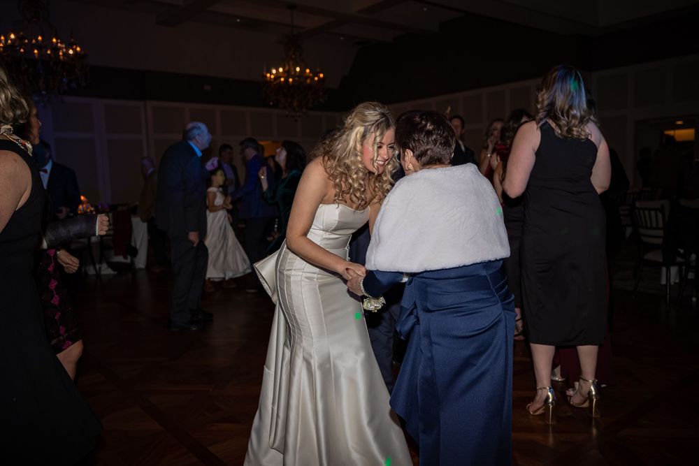 Wedding dancers enjoy themselves under twinkling lights at an evening reception.