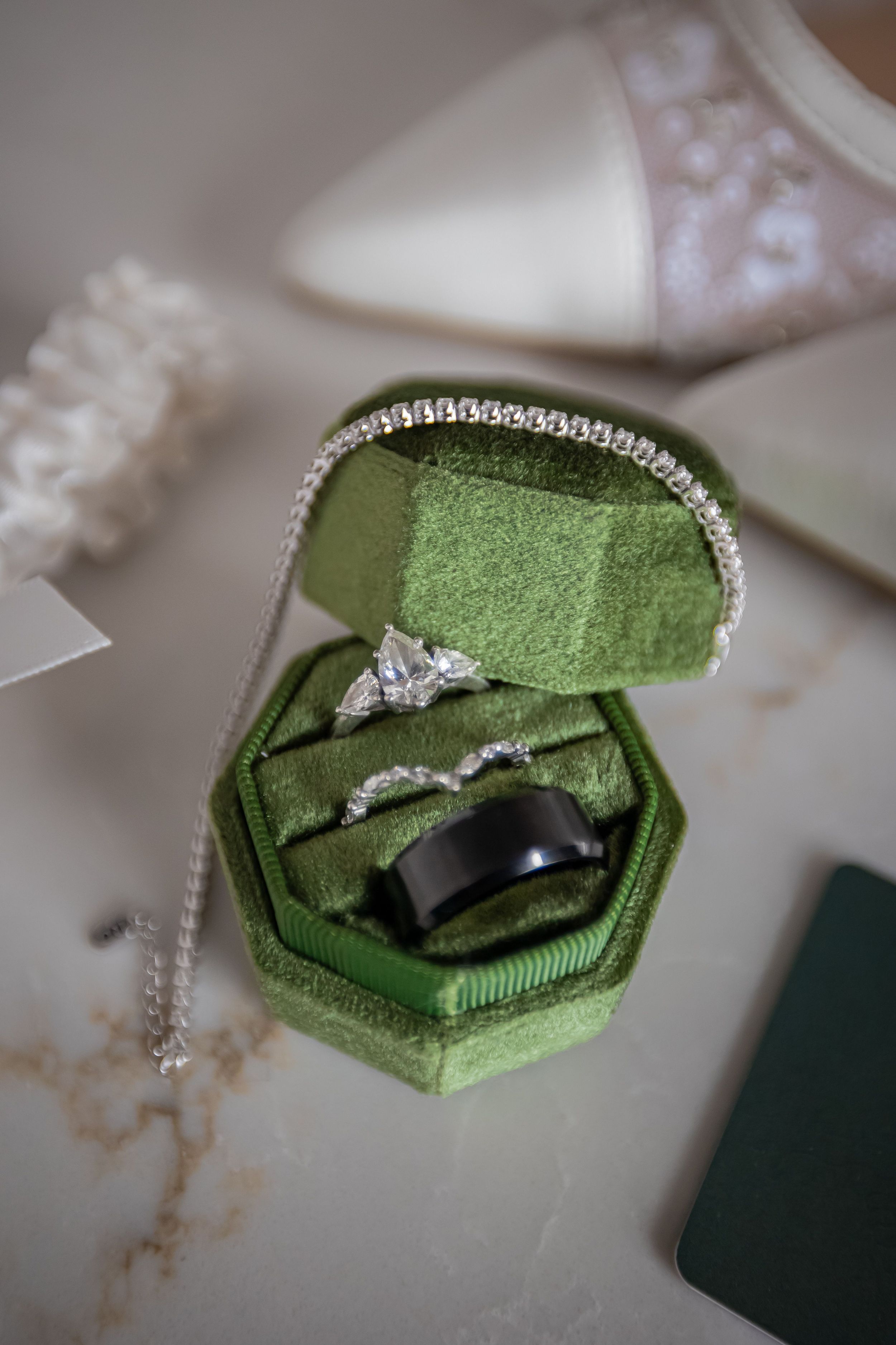 Green velvet ring box opens in sequence to reveal elegant diamond engagement ring with soft lighting and shallow depth of field.