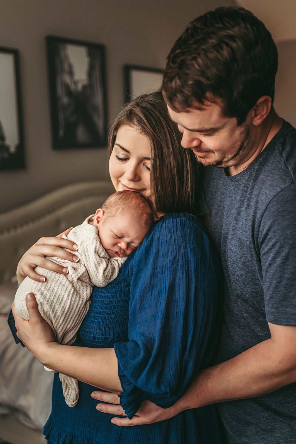 A peaceful family moment with parents holding their newborn baby together at a Chattanooga newborn session in their home.