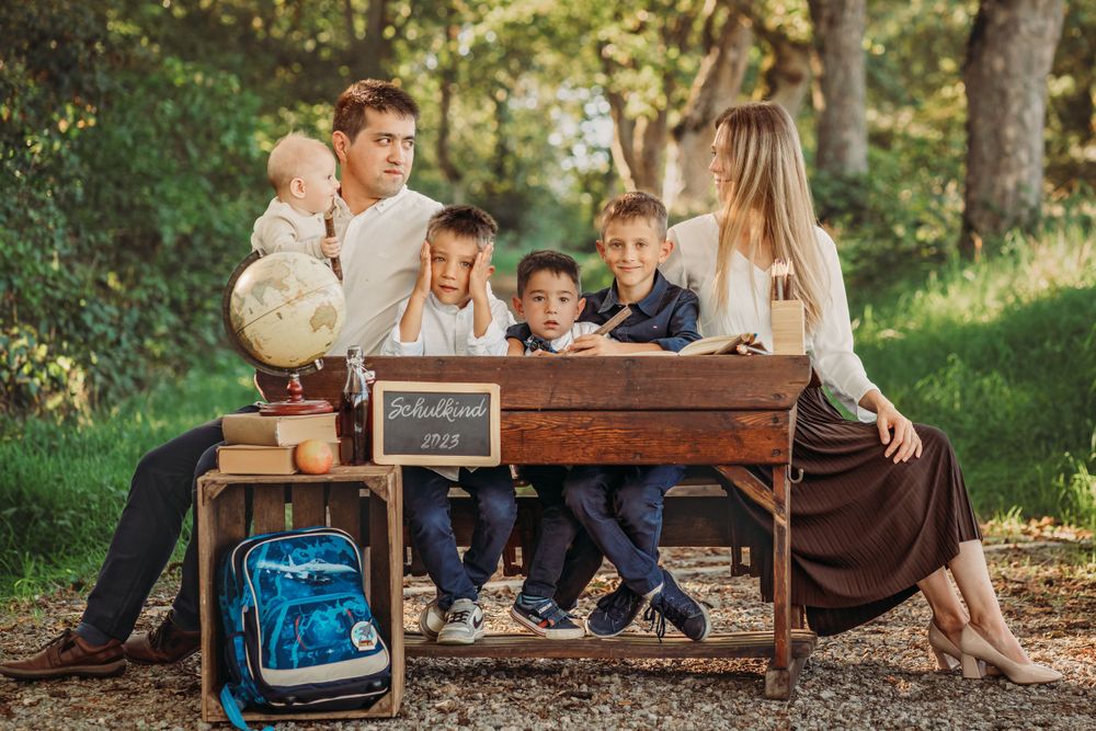 A family gathered around a vintage desk outdoors for a back-to-school themed portrait session.