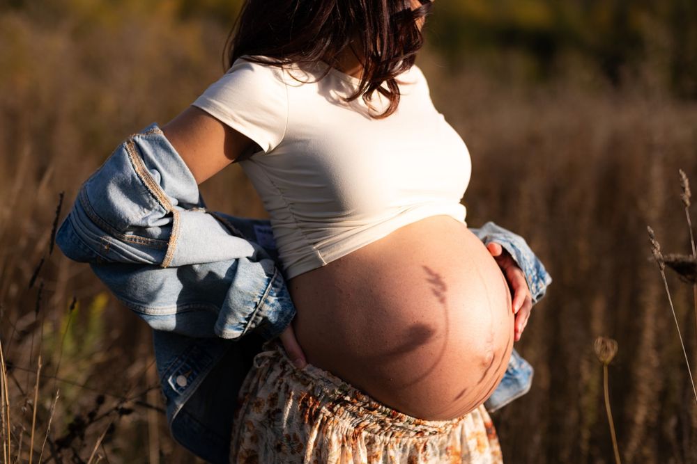 Maternity photoshoot in a rustic field during golden hour.