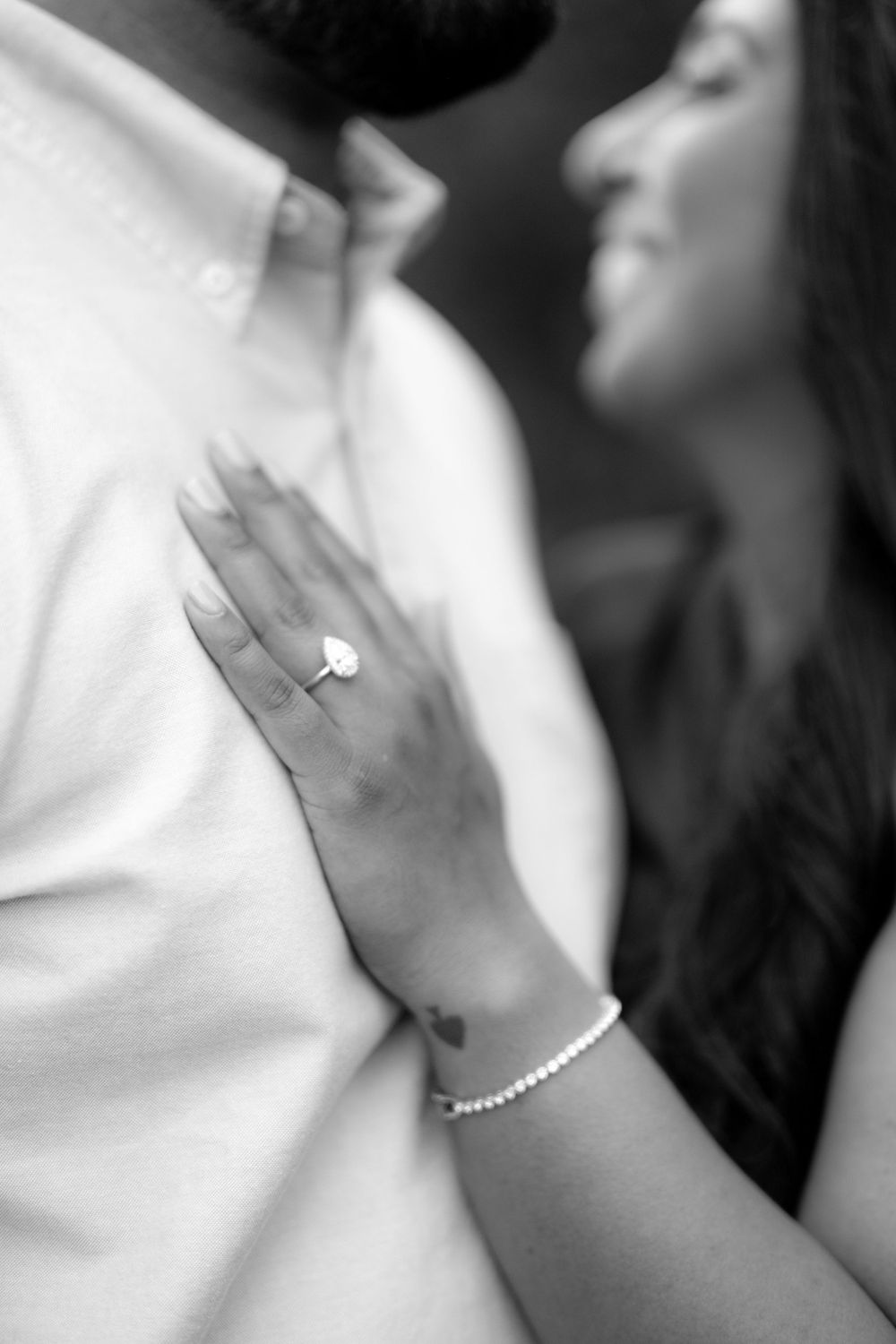 Close-up of hands with jewelry against a soft white background.