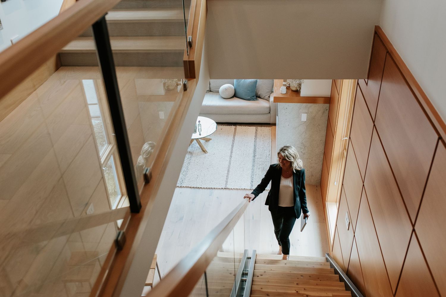 Real estate woman climbing stairs in Whistler home.
