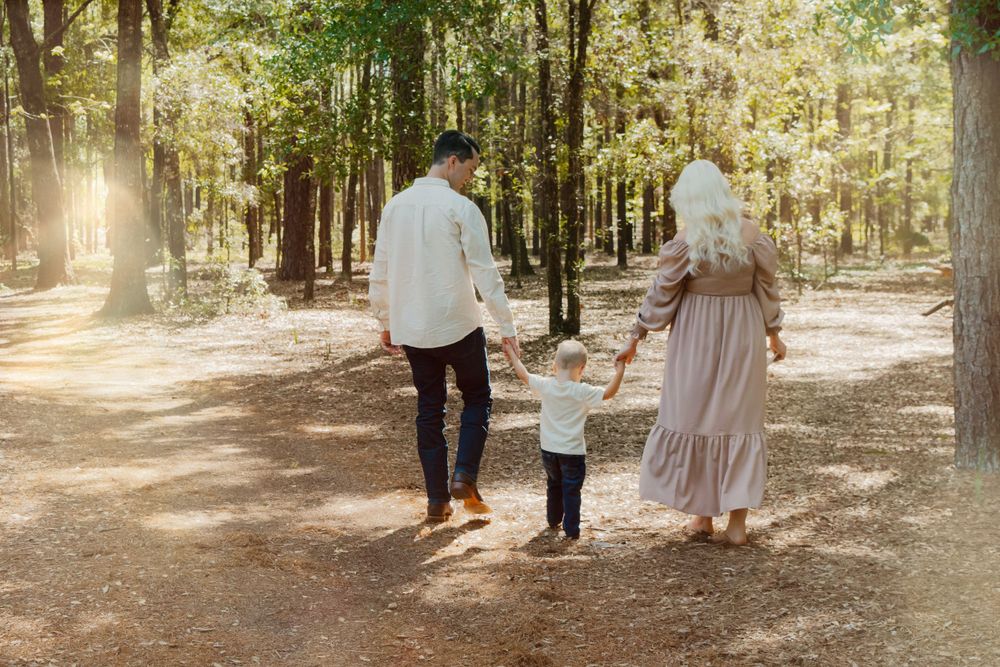 A heartwarming outdoor family photoshoot sequence in a sunlit wooded area showing a pregnancy announcement with ultrasound photos.
