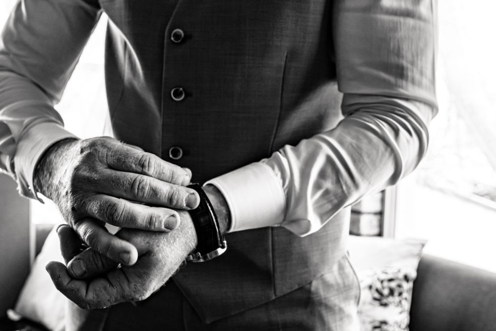 Close up of hands adjusting formal wear cuff links and sleeves.
