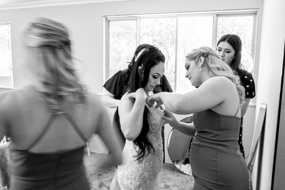 Black and white candid moment of wedding preparation excitement.