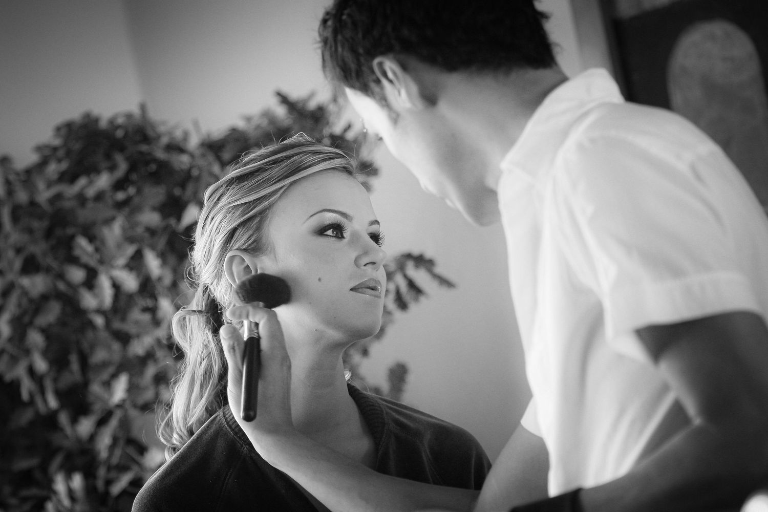 Black and white portrait capturing an intimate moment during wedding preparations.