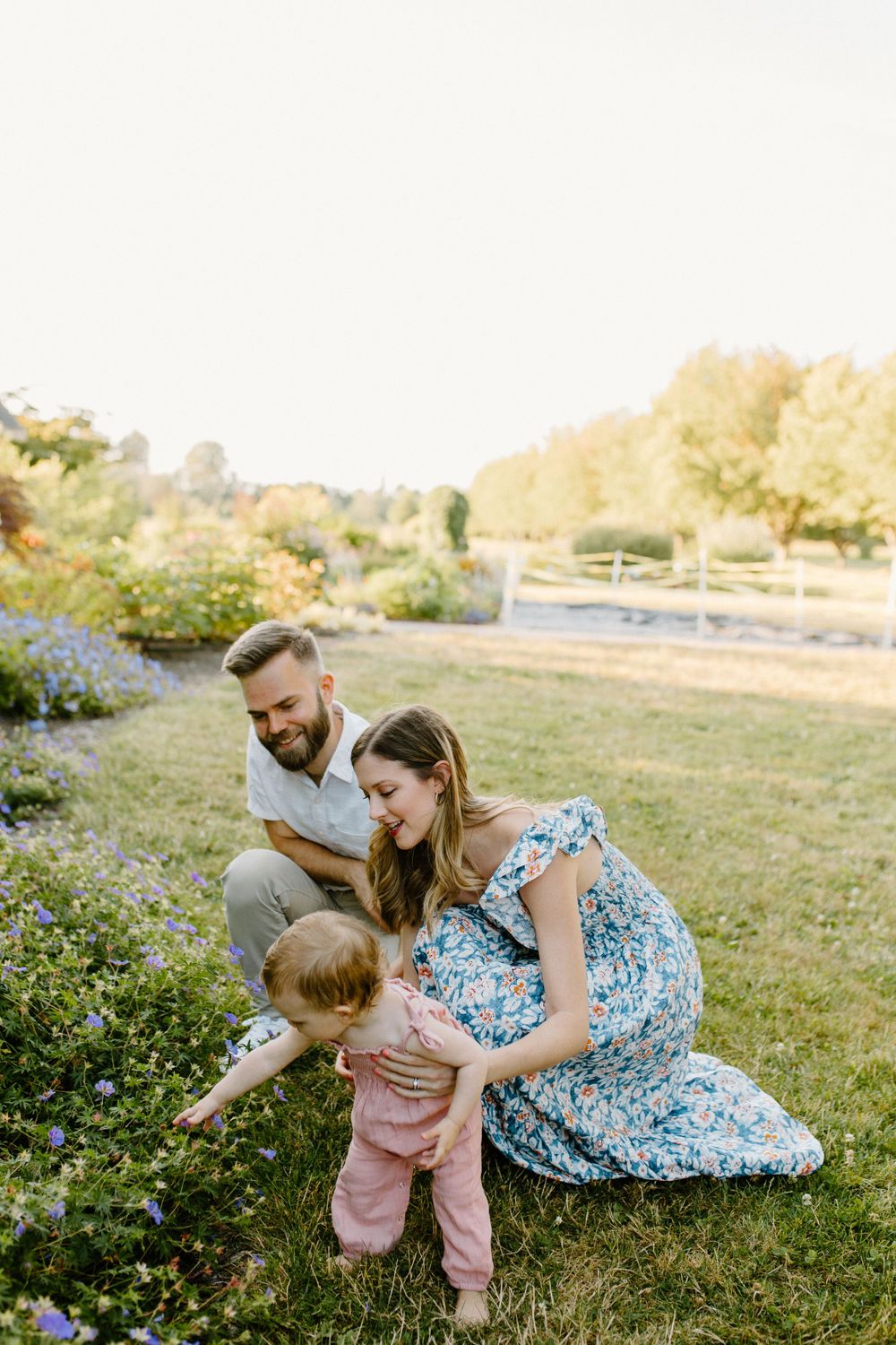Family moment in a garden with blooming flowers during golden hour.