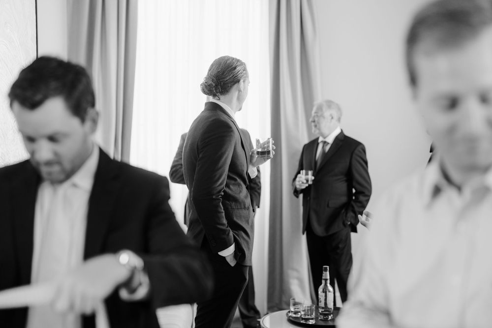 Group of people in formal attire gathered in a room preparing for an event. Photoshoot by Venice Photographer Alina Indi