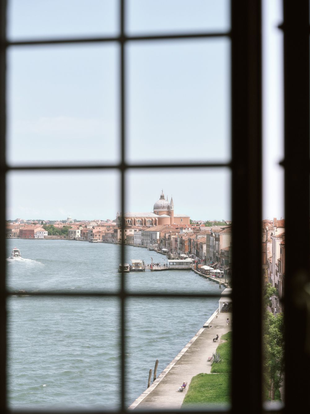 View of Venice's waterfront and historic buildings through window bars.