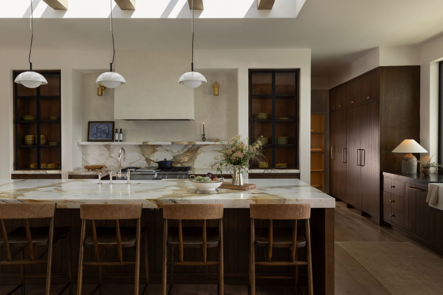Modern minimalist kitchen with white cabinets, wooden countertops and ambient lighting.