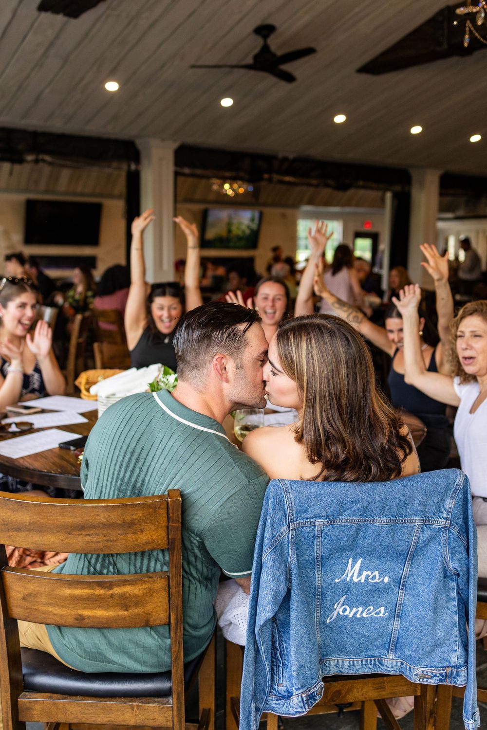 Celebration scene at restaurant with customized denim jacket and excited guests.