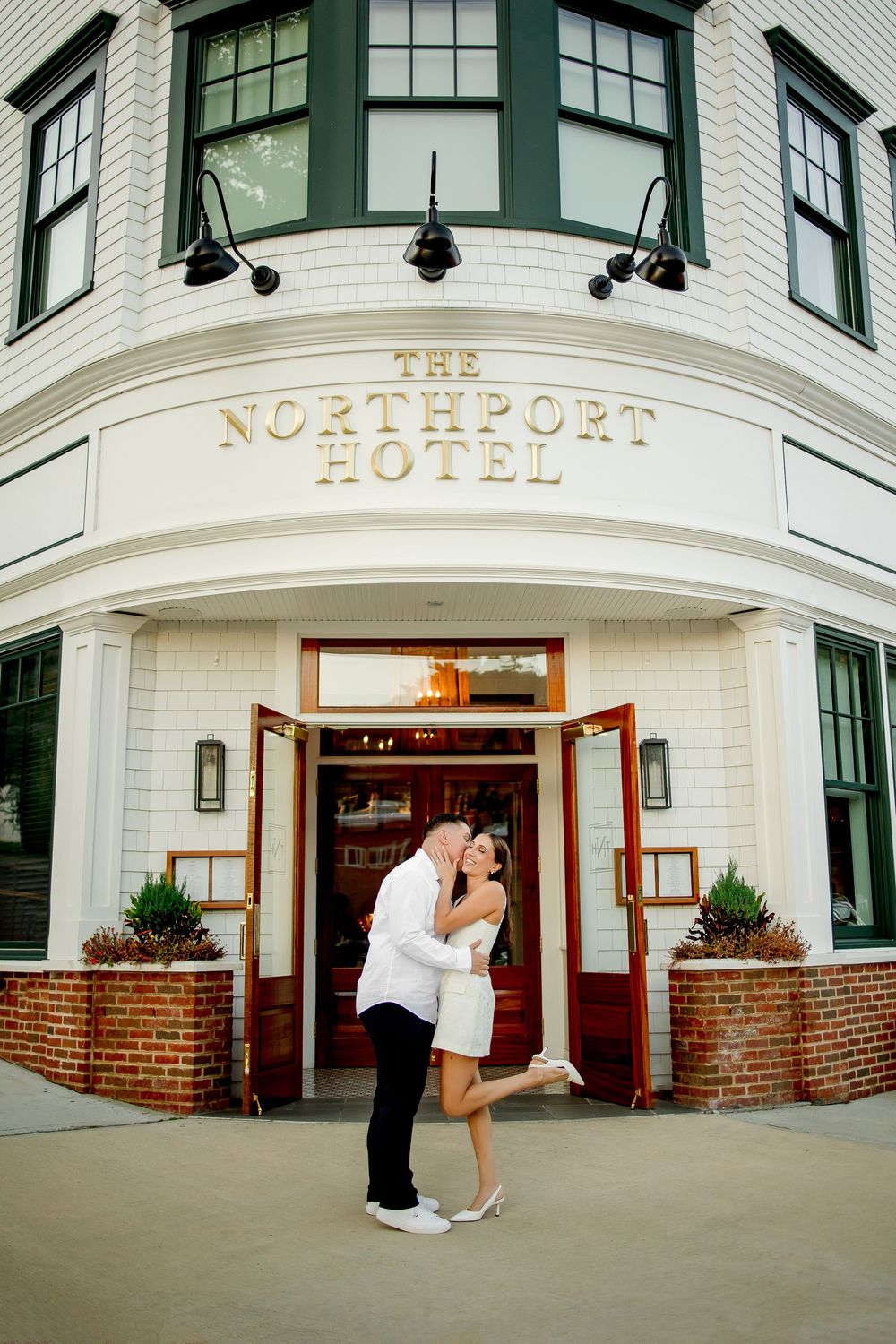 A couple in formal attire shares a romantic moment outside The Northpoint Hotel entrance.