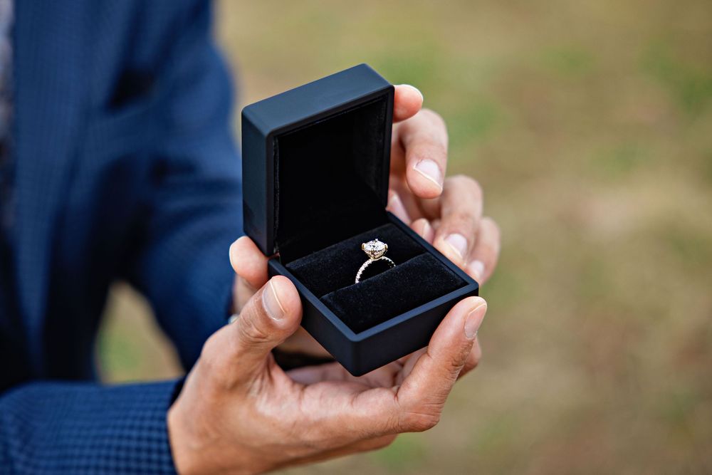 Close-up sequence showing a small black jewelry box being opened to reveal contents inside.