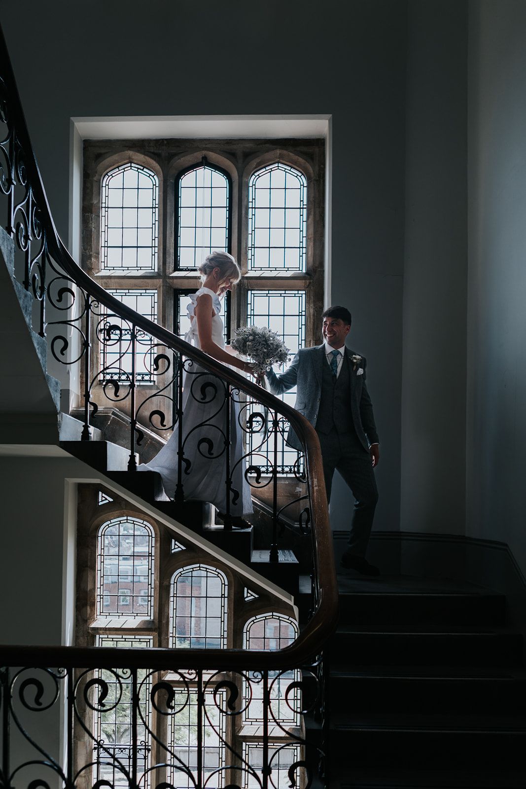 bride and groom walking down the stairs at Winchester registry office