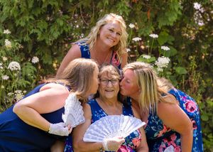 Cheerful gathering of women in matching floral dresses with decorative fans.