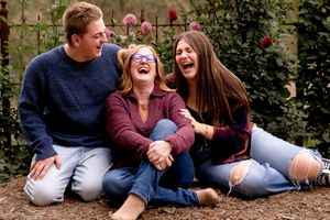 Candid moment of laughter while sitting together in a garden setting with roses.