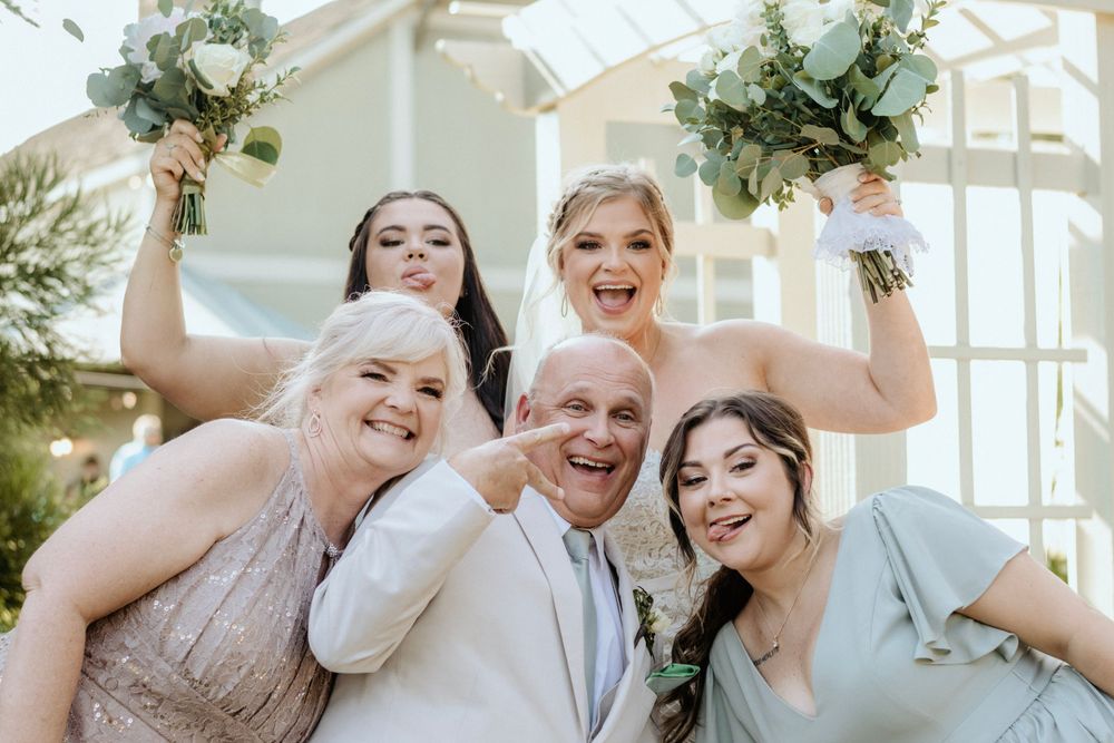 Wedding party having fun and celebrating with joyful expressions outdoors.