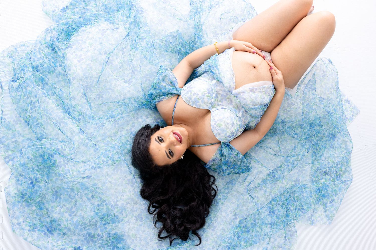 An expectant mother showcases her baby bump during a photo shoot at a photography Studio in Cedar Park Texas