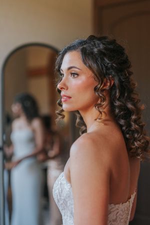 A bride with dark curly hair and a strapless wedding dress gazes elegantly to the side. Central Indiana Wedding Photography