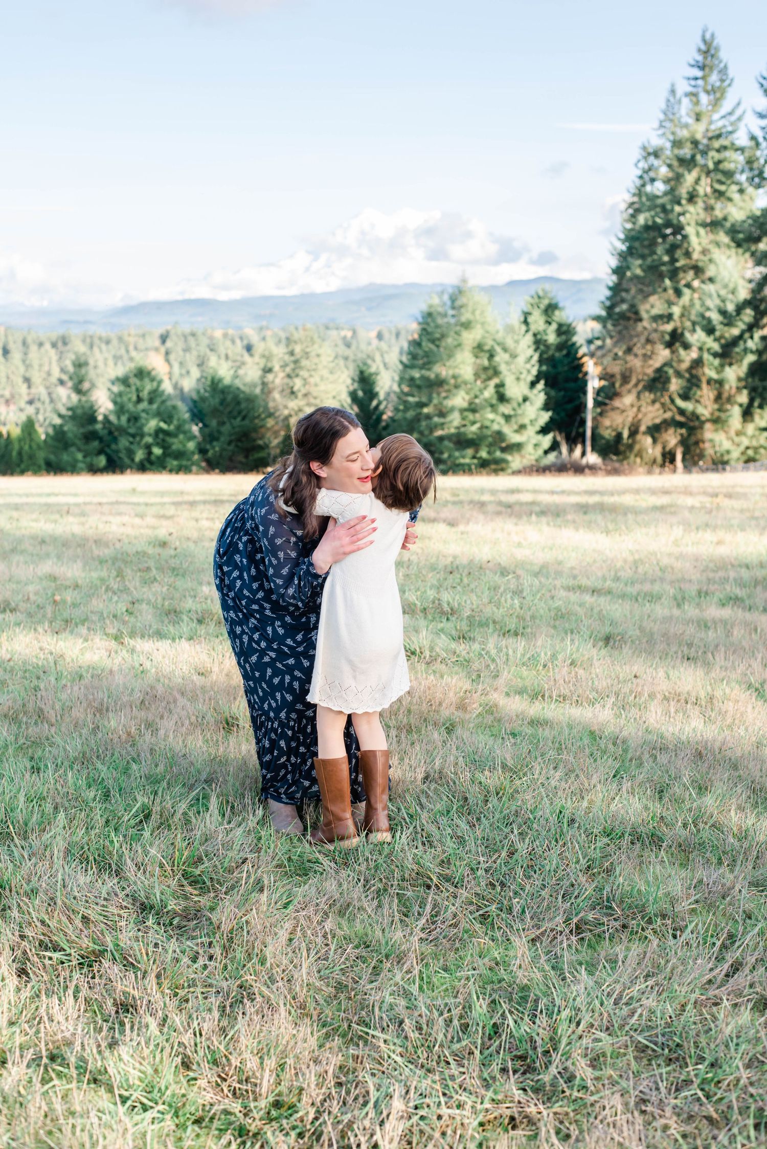 Loving family moment captured in rustic mountain meadow at sunset.