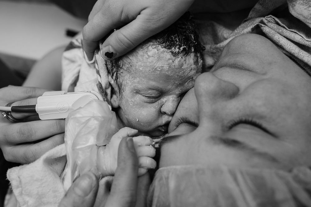 Black and white image capturing a newborn's first moments.