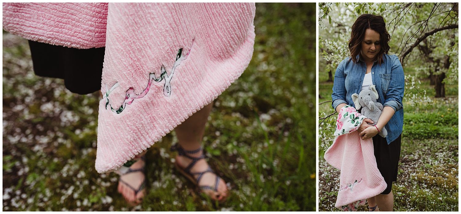 Detail shot of embroidered pink blanket with family portrait in orchard background.