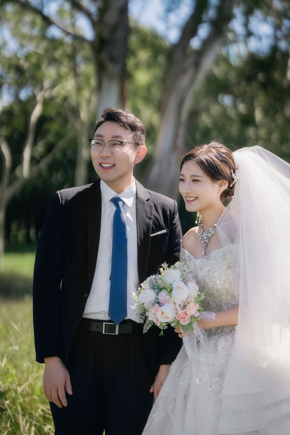Stunning and happy couple enjoying afternoon sunlight in a natural botanical garden wedding portrait, by Imagine Image Studio Auckland.