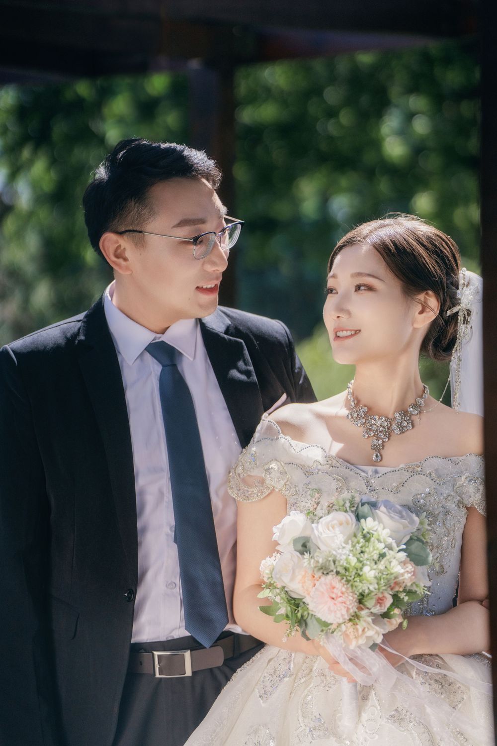 Stunning and happy couple enjoying afternoon sunlight in a natural botanical garden wedding portrait, by Imagine Image Studio Auckland.