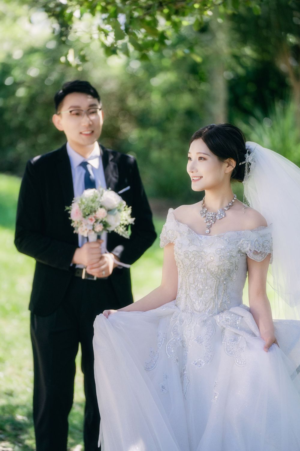 Stunning and happy couple enjoying afternoon sunlight in a natural botanical garden wedding portrait, by Imagine Image Studio Auckland.